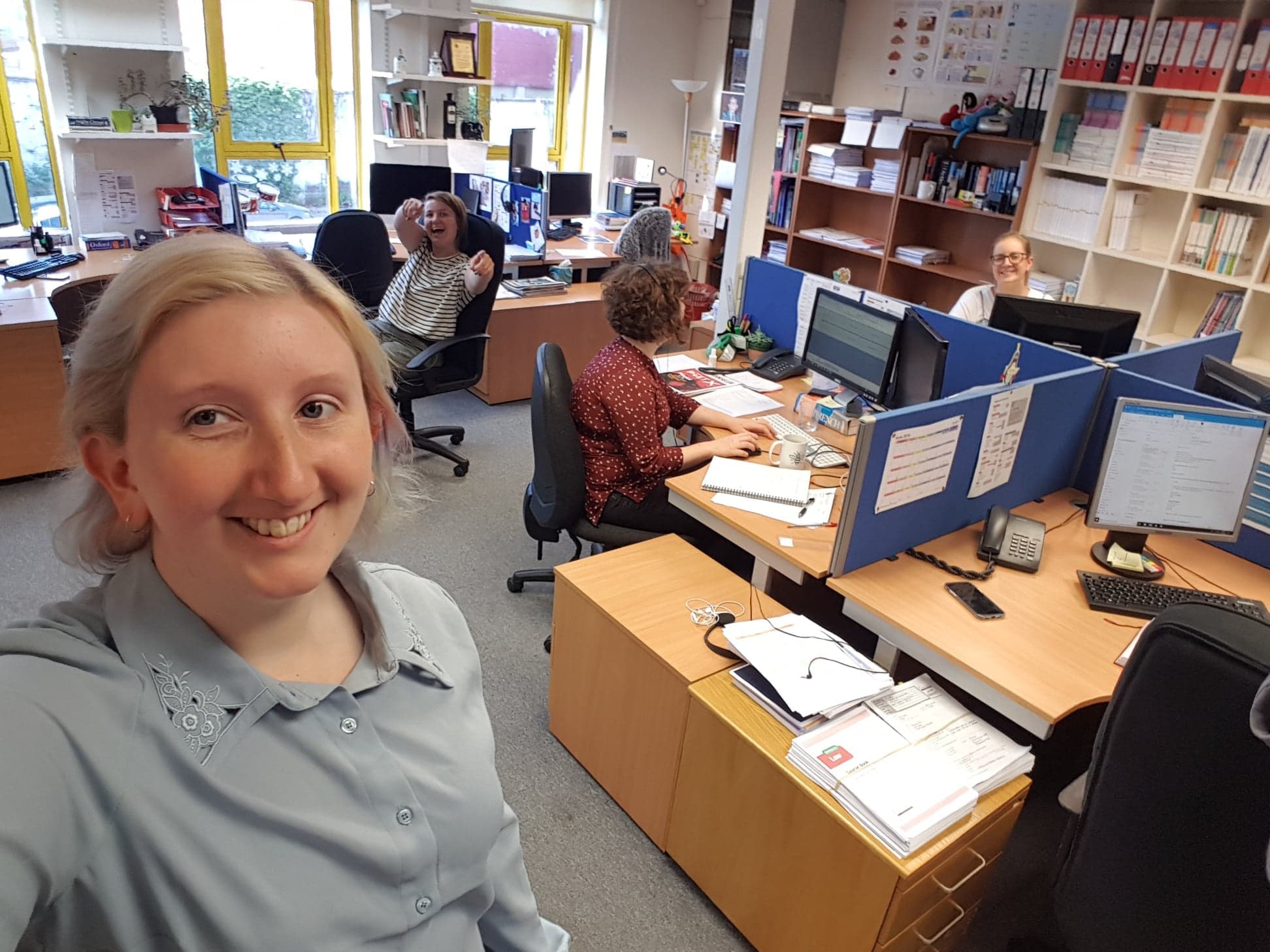 A selfie of Alice, a young blonde haired woman, in the office.
