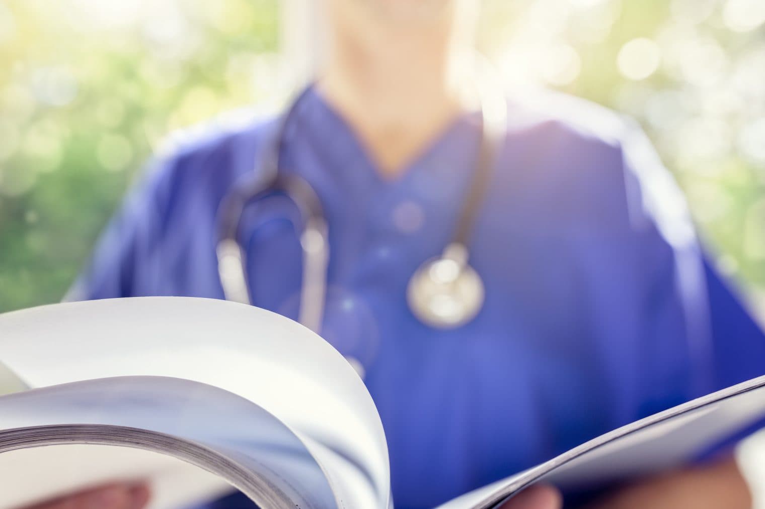 Close-up of a doctor flicking through papers.