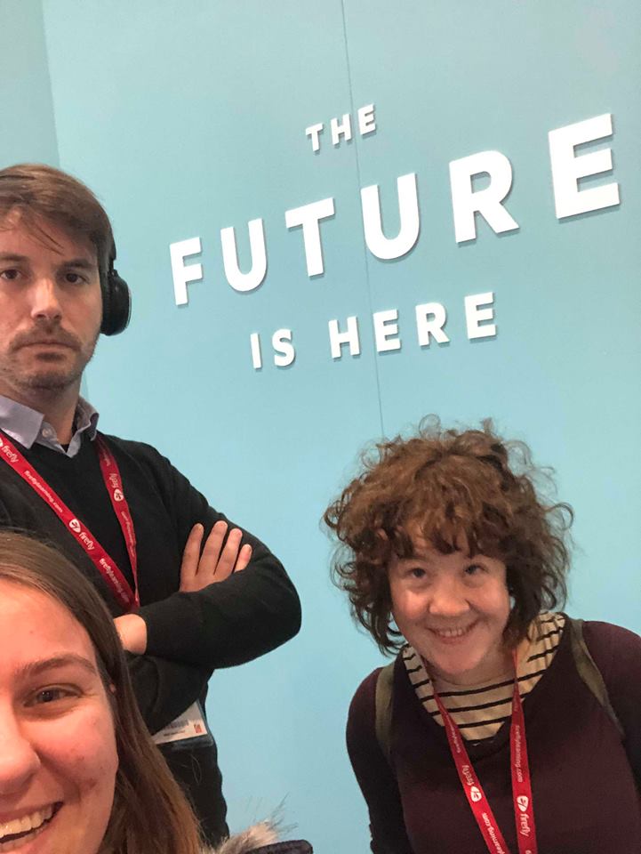 A selfie of Matt, Rosie and Jaz stood infront of a wall which says 'The Future is Here.'