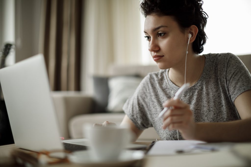 Young woman studying at home on a laptop.