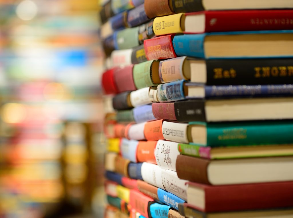 Close up of an infinite stack of colourful books in a library. 