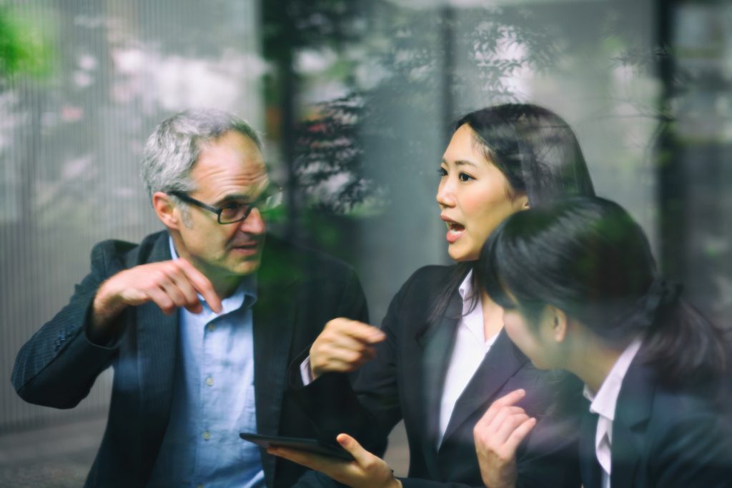 A business discussion with two women and a man communicating to solve a problem