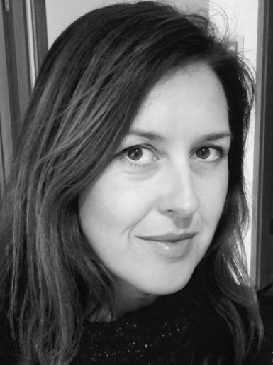 Black and white photo of Nicola Meldrum, a friendly looking woman with brunette hair.